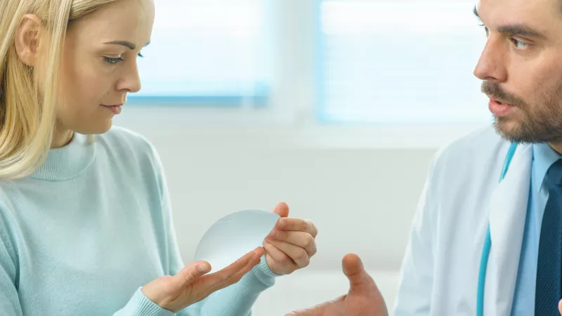 stock image of a woman looking at a breast implant