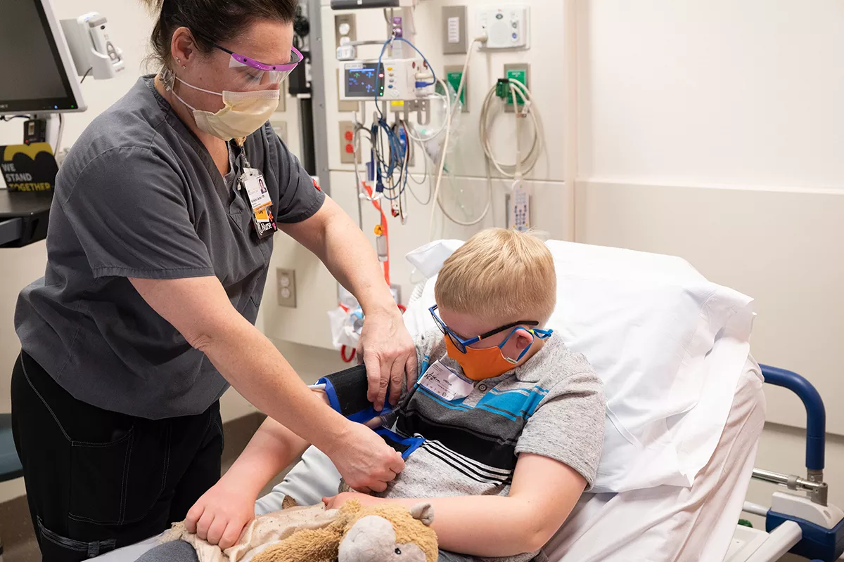Nurse puts a blood pressure cuff on a child's arm