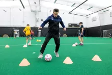 Jon Cook coaches and demonstrates skills during a soccer skills practice at Hawkeye Tennis & Recreation Complex on Wednesday, December 21, 2022. Dr. Nicolas Noiseux performed a total knee replacement on Cook’s left knee in January 2022.