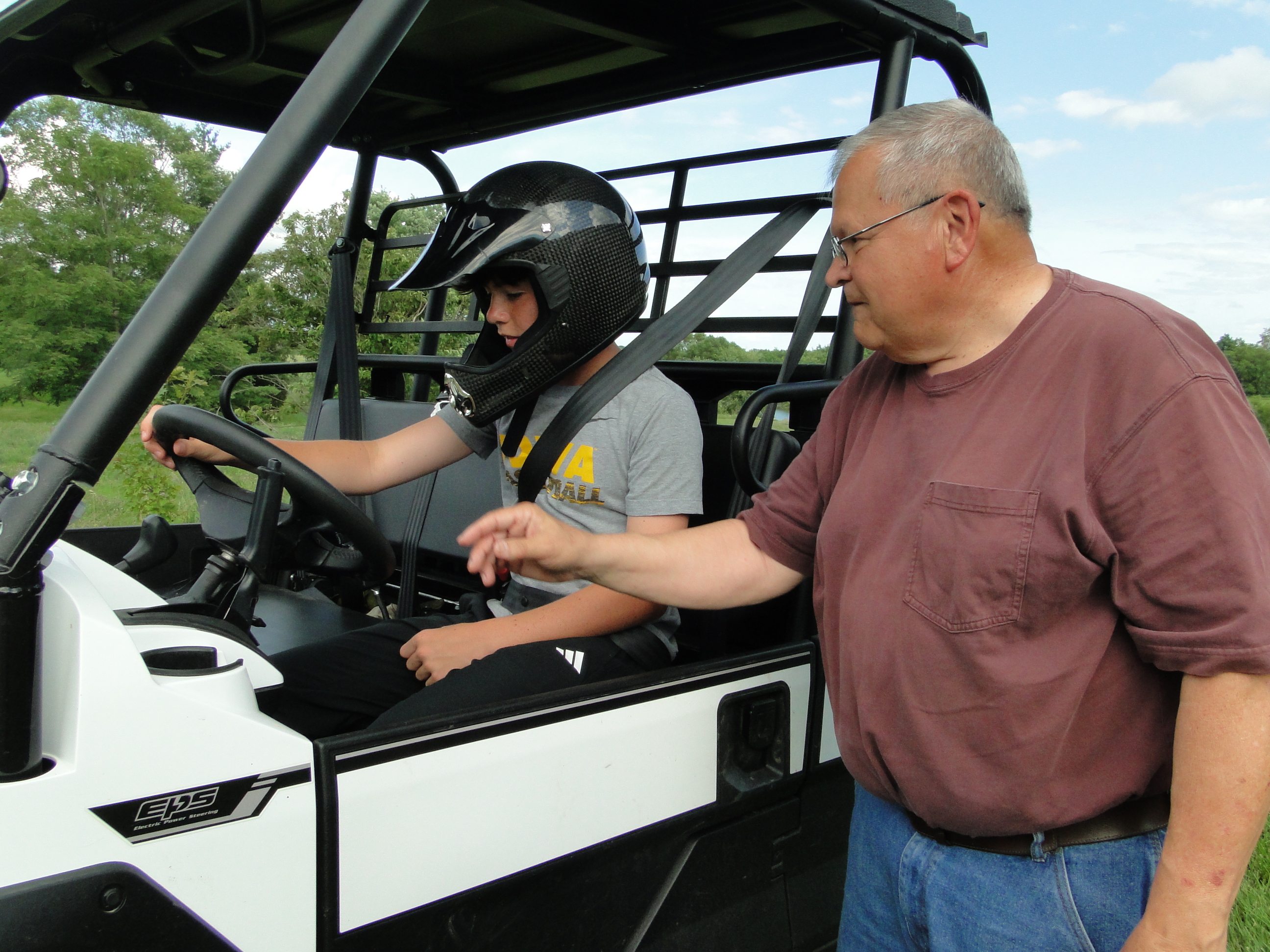 Adult showing child proper UTV safety