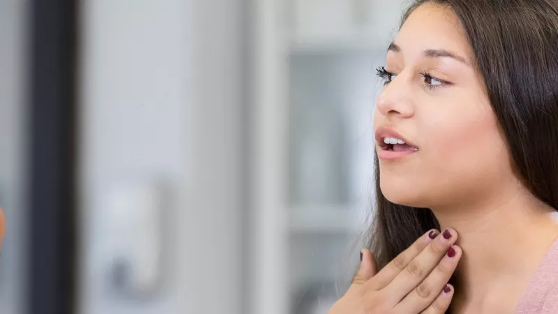 stock image of a woman touching the skin of her neck