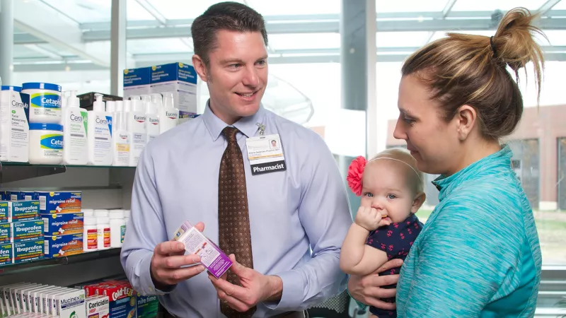 A UI Health Care pharmacist shows medication to a patient at Iowa River Landing