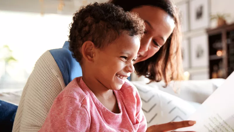 Stock image of a child reading with their parent