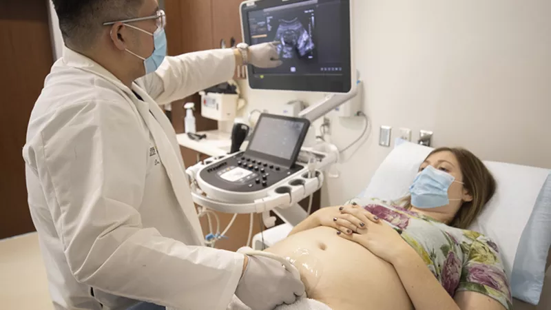 Mark Santillan, MD, PhD, performs an ultrasound on a pregnant patient