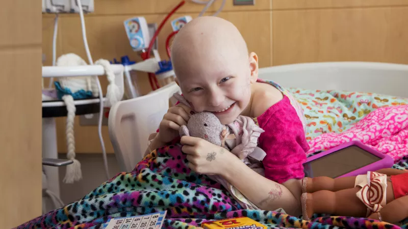 Photo of a patient at UI Stead Family Children's Hospital within her hospital room, smiling.