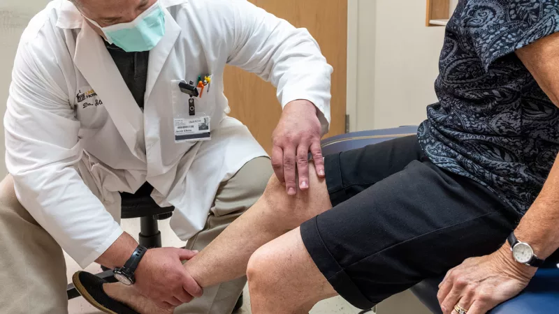 Jacob Elkins examines the knee of a simulated patient in the Orthopedic Clinic