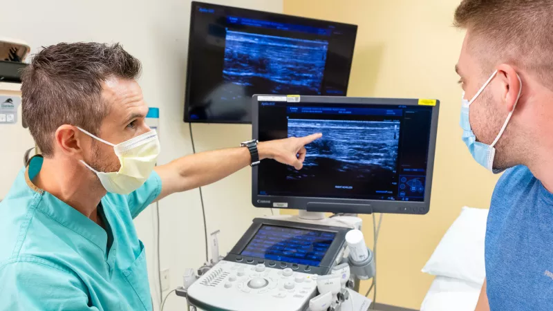 Mederic Hall performs an ultrasound on a simulated patient’s achilles tendon in a procedure room at University of Iowa Health Care Sports Medicine clinic in Iowa City on Tuesday, Aug. 9, 2022.