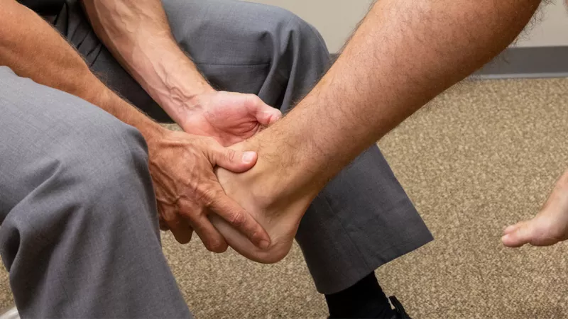 Andrew Peterson examines a simulated patient’s ankle and foot at University of Iowa Health Care Sports Medicine clinic in Iowa City on Tuesday, Aug. 9, 2022.