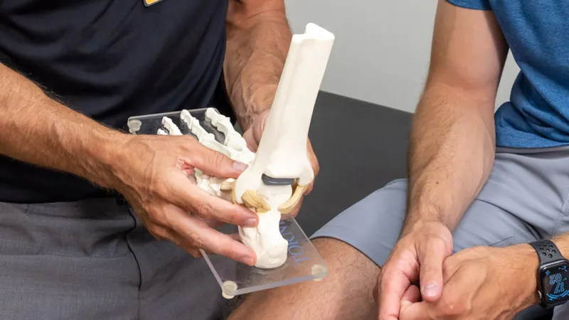 Andrew Peterson examines a simulated patient’s ankle and foot at University of Iowa Health Care Sports Medicine clinic in Iowa City on Tuesday, Aug. 9, 2022.