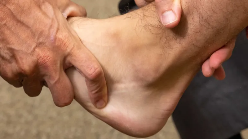 Provider examines a patient's ankle and foot podiatry banner