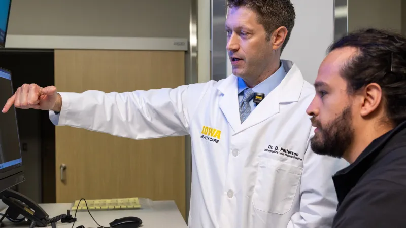 Brendan Patterson, MD, with resident John Davison, MD, in the Orthopedics clinic at UI Health Care Medical Center North Liberty on Tuesday, April 29, 2025. 