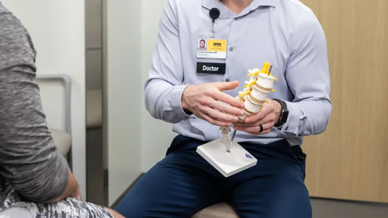 Joshua Eisenberg, MD, with simulated spine patient in the orthopedics clinic at UI Health Care Medical Center North Liberty on Tuesday, April 29, 2025. 