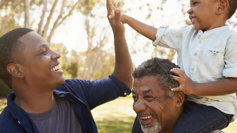 A stock photo of a dad and son high fiving.