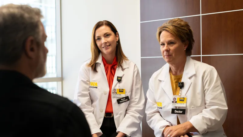 Staged photo of cancer providers discussing care with a fake patient