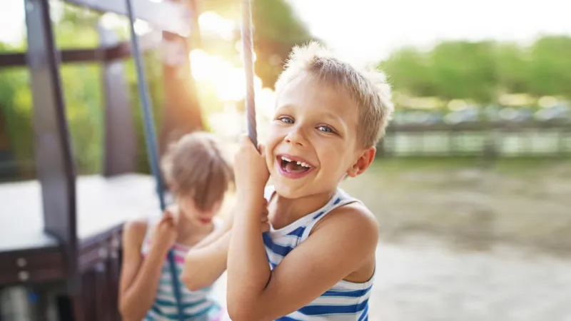 Young boy swinging in the sun