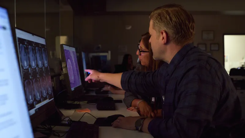 Two Mission providers review a computer screen with scans from a patient.
