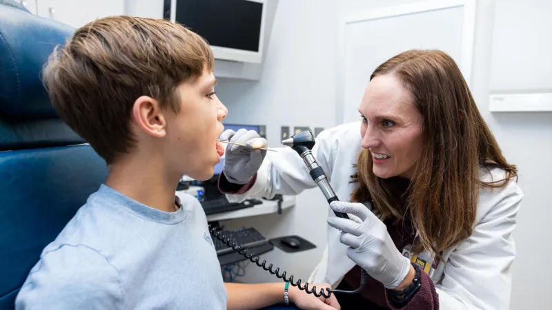 Doctor with child looking into mouth
