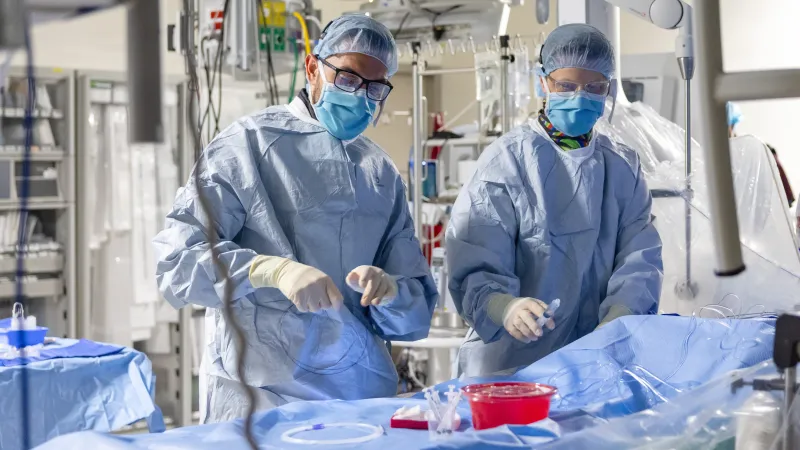 Cardiologist Kamel Shibbani, MD, and pediatric cardiology fellow Aaron Heaps, MD, in the pediatric cath lab