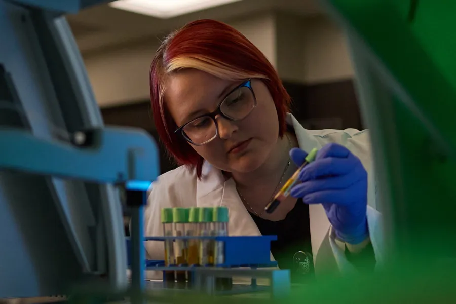 A lab worker reviews patient material in a lab at a Mission Cancer + Blood location