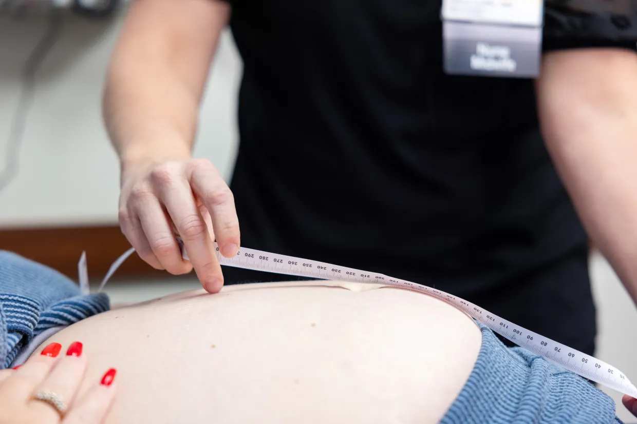 UI Health Care provider measuring the belly of a pregnant woman.
