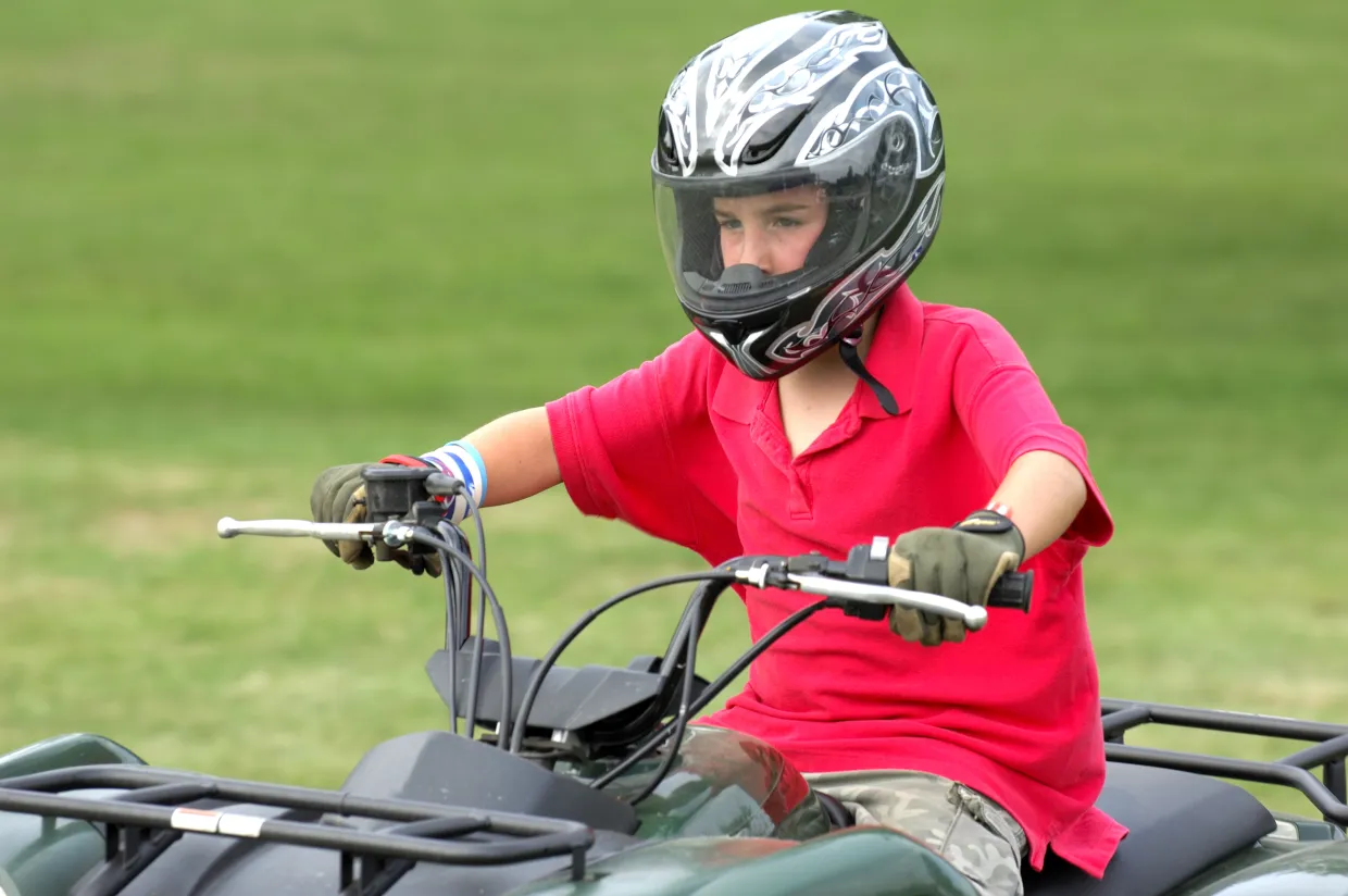 Young boy rides an ATV.