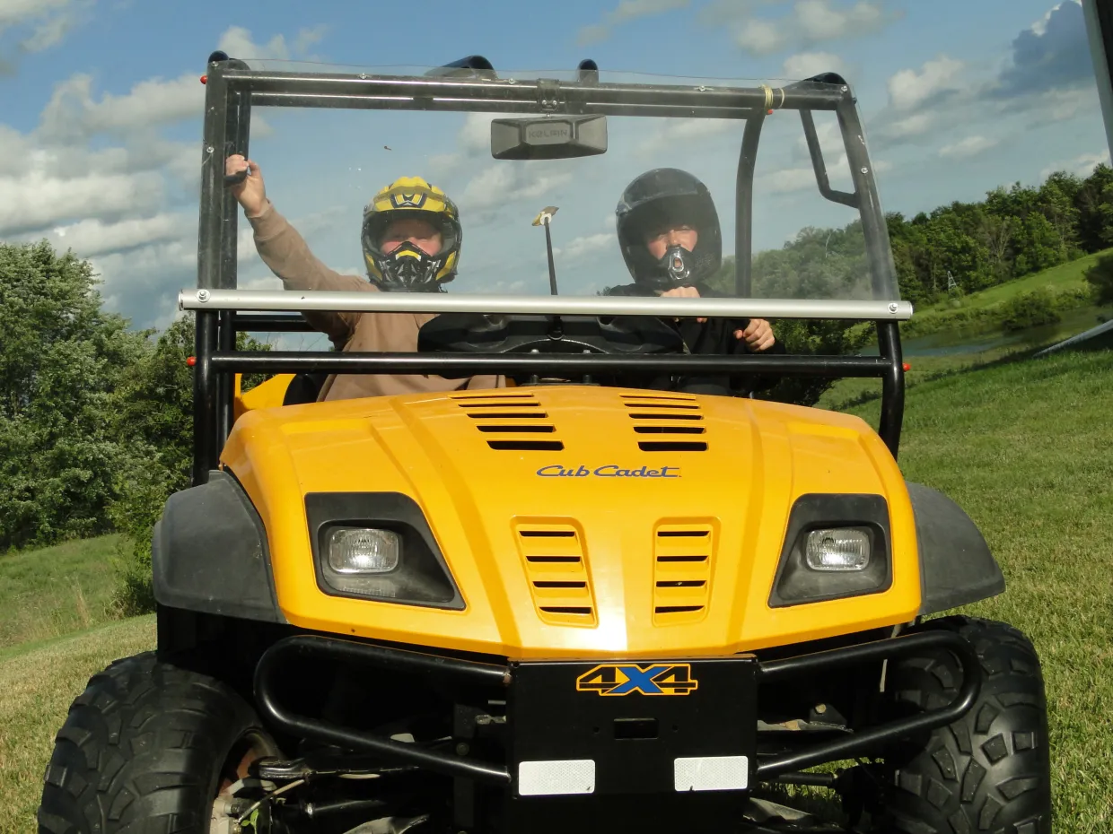 Two children riding an Utility task vehicle (UTV)