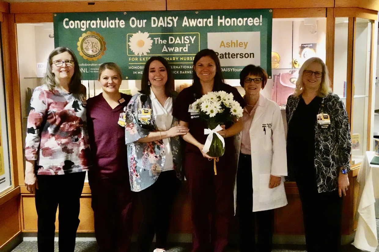 Ashley Patterson, BSN, RN receiving her Daisy Award surrounded by teammates