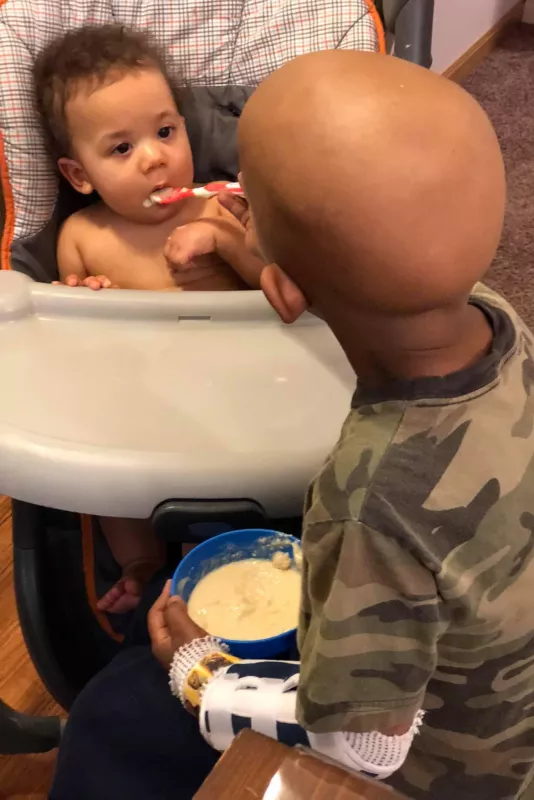 Eli feeding his little sister