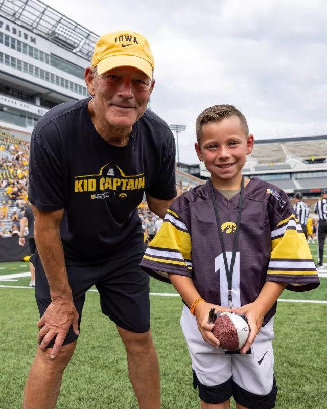 Tate Manahl and coach Kirk Ferentz duing Kids Day at Kinnick Stadium.