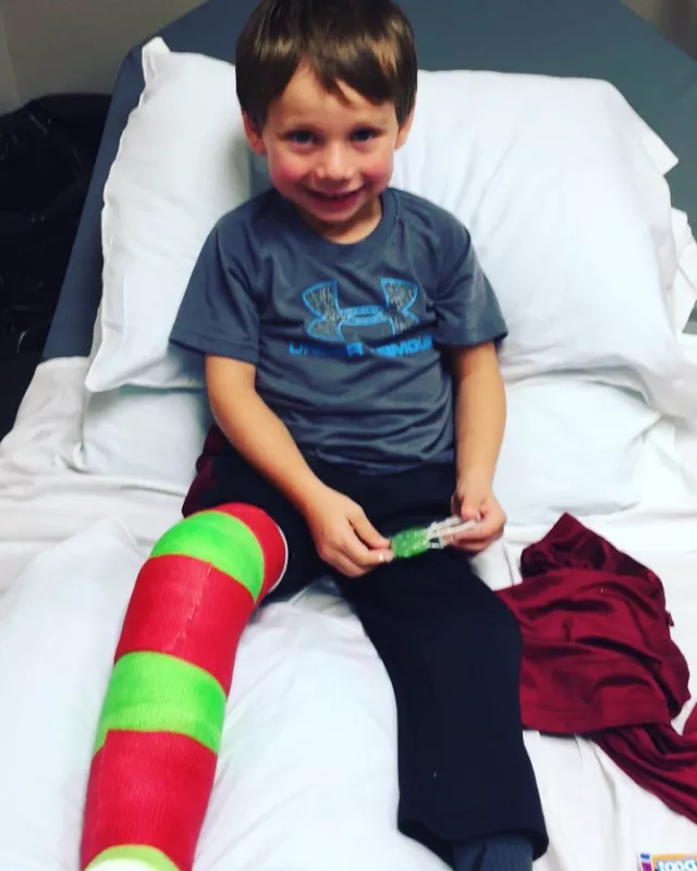 Tate Manahl shows off his green and red cast