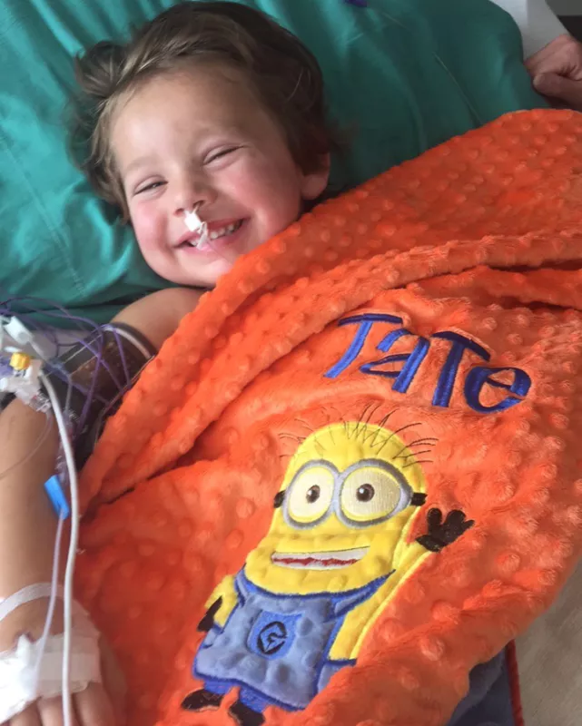 Tate Manahl smiles with his "Tate" blanket
