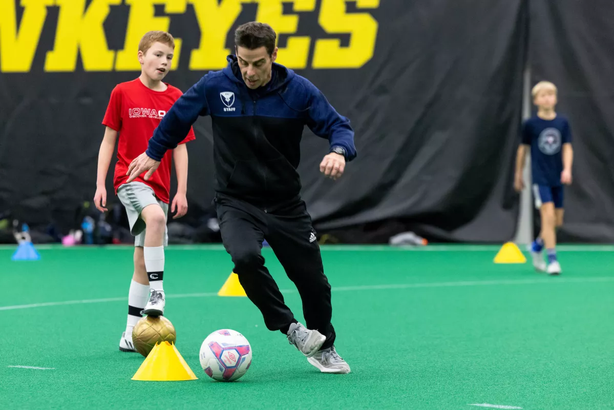 Jon Cook coaches and demonstrates skills during a soccer skills practice at Hawkeye Tennis & Recreation Complex on Wednesday, December 21, 2022. Dr. Nicolas Noiseux performed a total knee replacement on Cook’s left knee in January 2022.