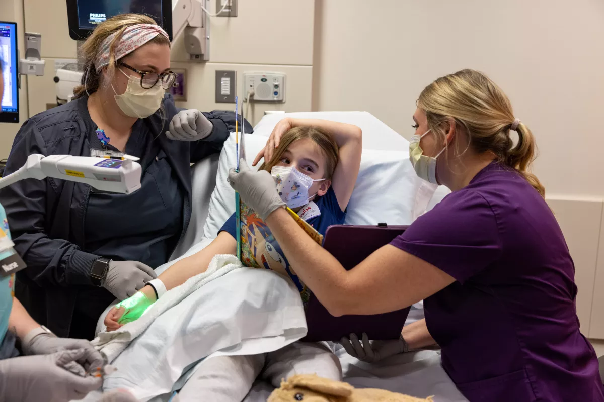 Staff nurse Raleigh Redenius and child life specialist Kristen Rooney distract a pediatric patient as she is prepared for MRI on Friday, February 24, 2023. Patient consent on file.