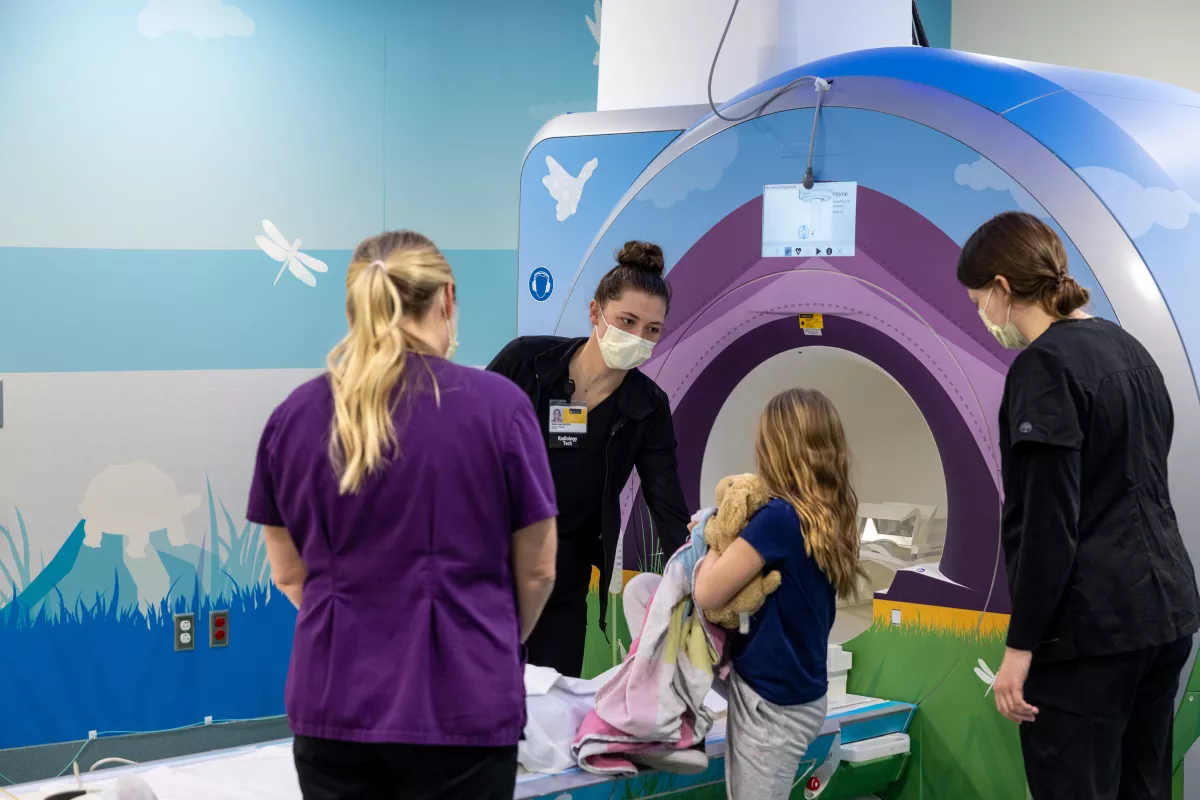 Child life specialist Kristen Rooney and imaging technologists Kallie Hirl and Alaina Rober with pediatric patient prepare for MRI in special wrapped MRI machines on Friday, February 24, 2023. Patient consent on file.
