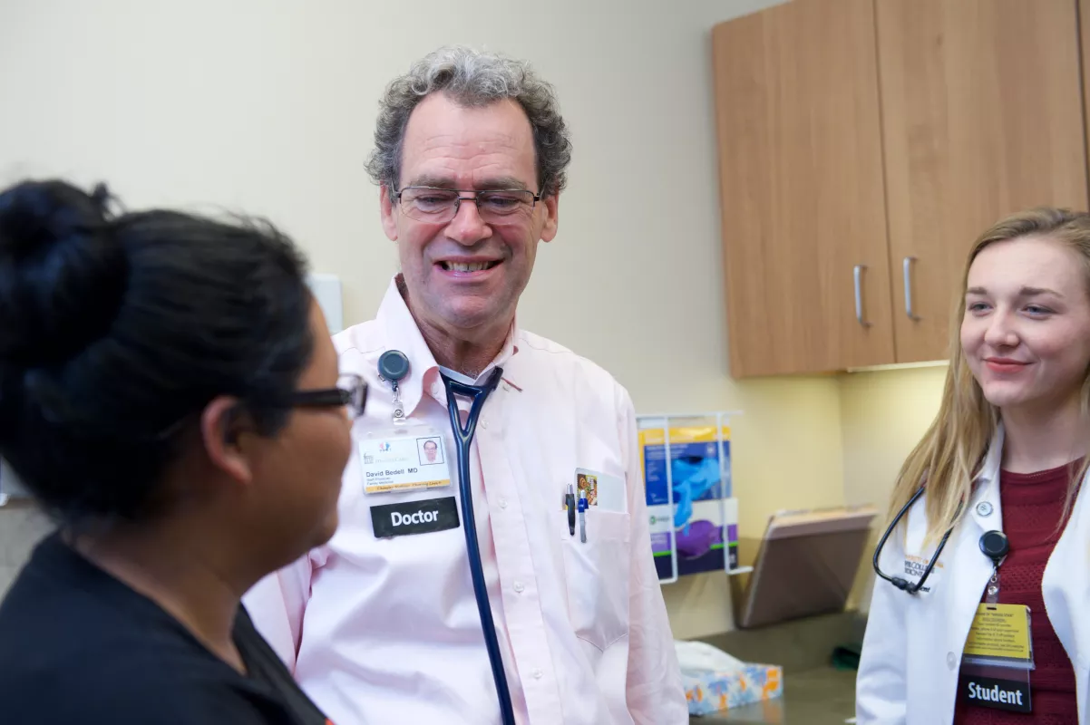 Family medicine physician David Bedell, MD, attends to patient with a medical student