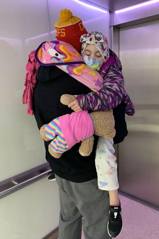 Marty carries his daughter Gracelyn to the elevator door