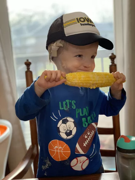 Young Nile Kron eating corn on the cob