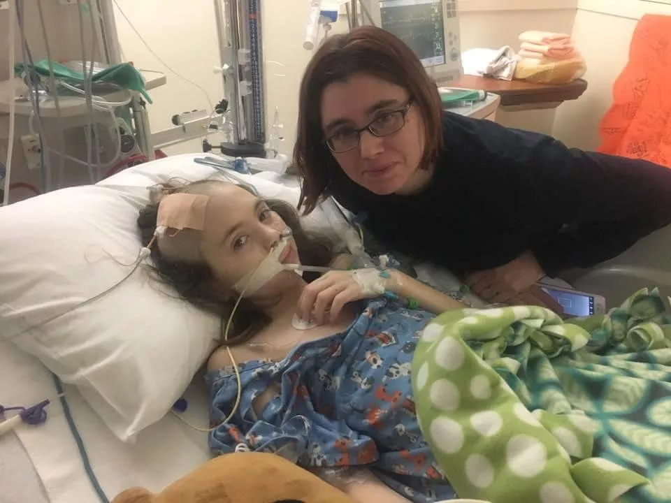 Gabby ford in hospital bed with Mom alongside her, February 2017