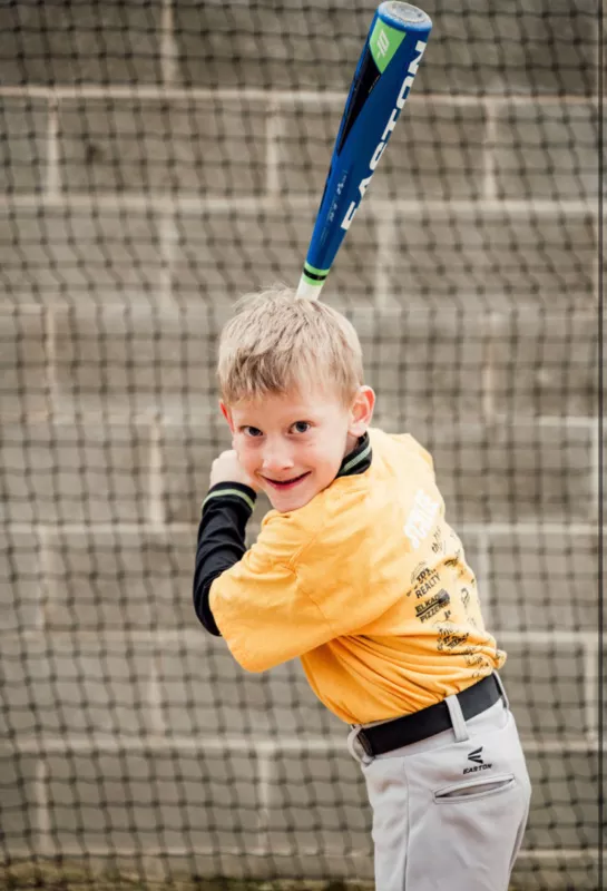 Max Schlee playing baseball and holding a bat