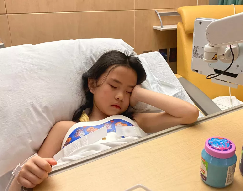 Kid Captain Chloe Dinkla laying in hospital bed