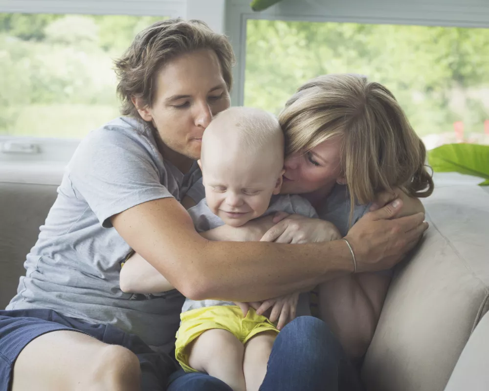 Kid captain Atlas Coleman and his parents in a hug