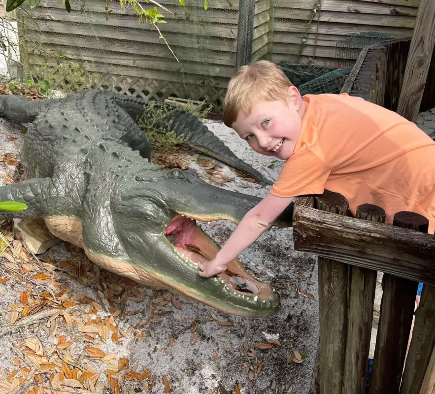 Kid Captain Aiden Washburn standing over a plastic alligator