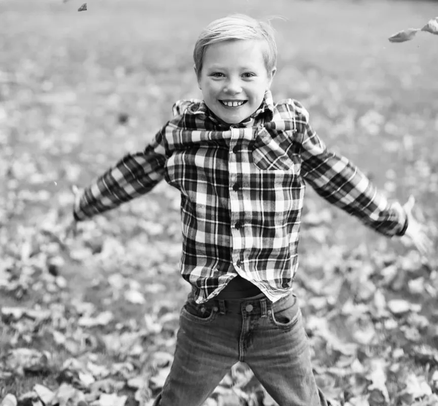 Kid Captain Aiden Washburn jumping in leaves