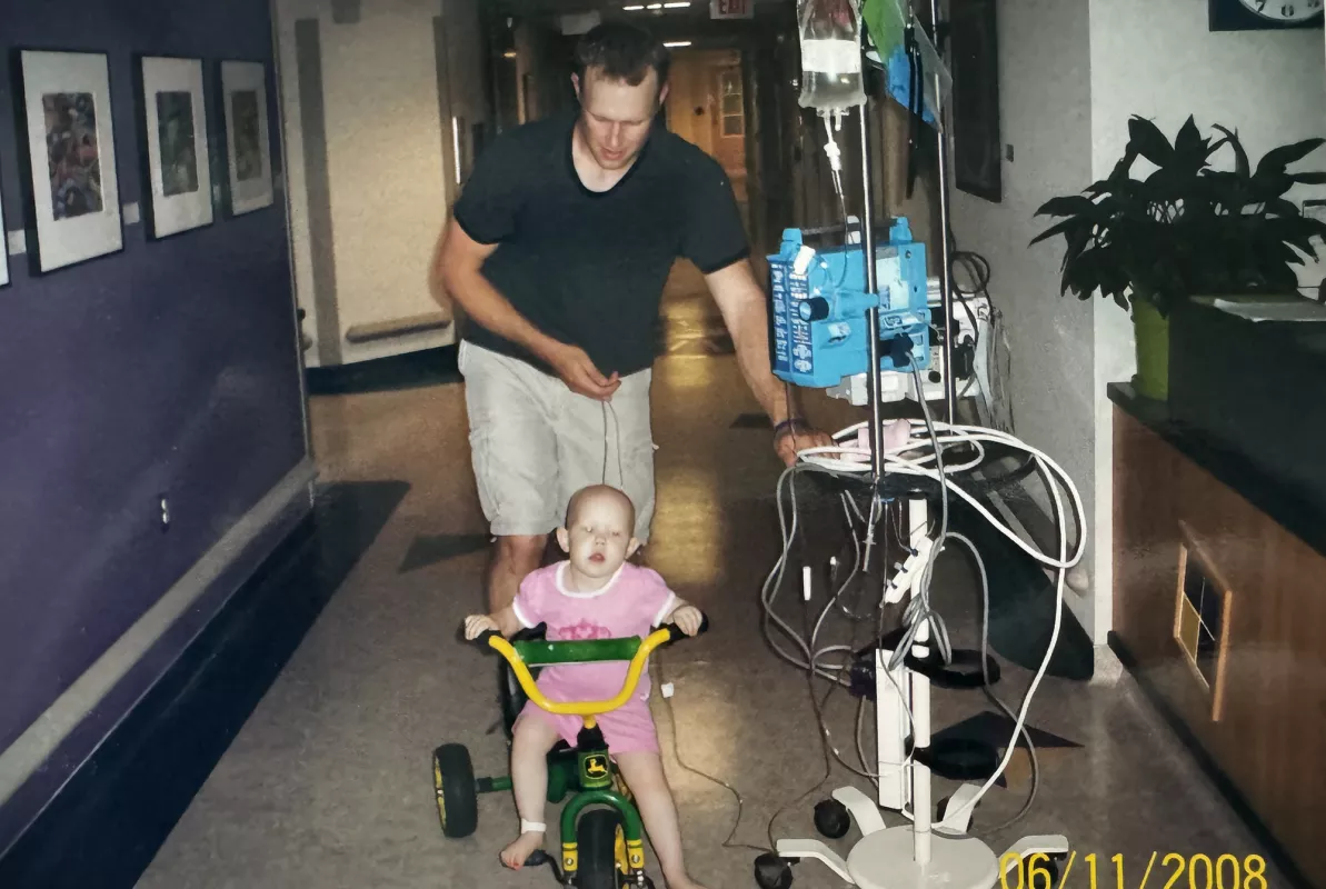 May Gilchrist riding a bike as an toddler