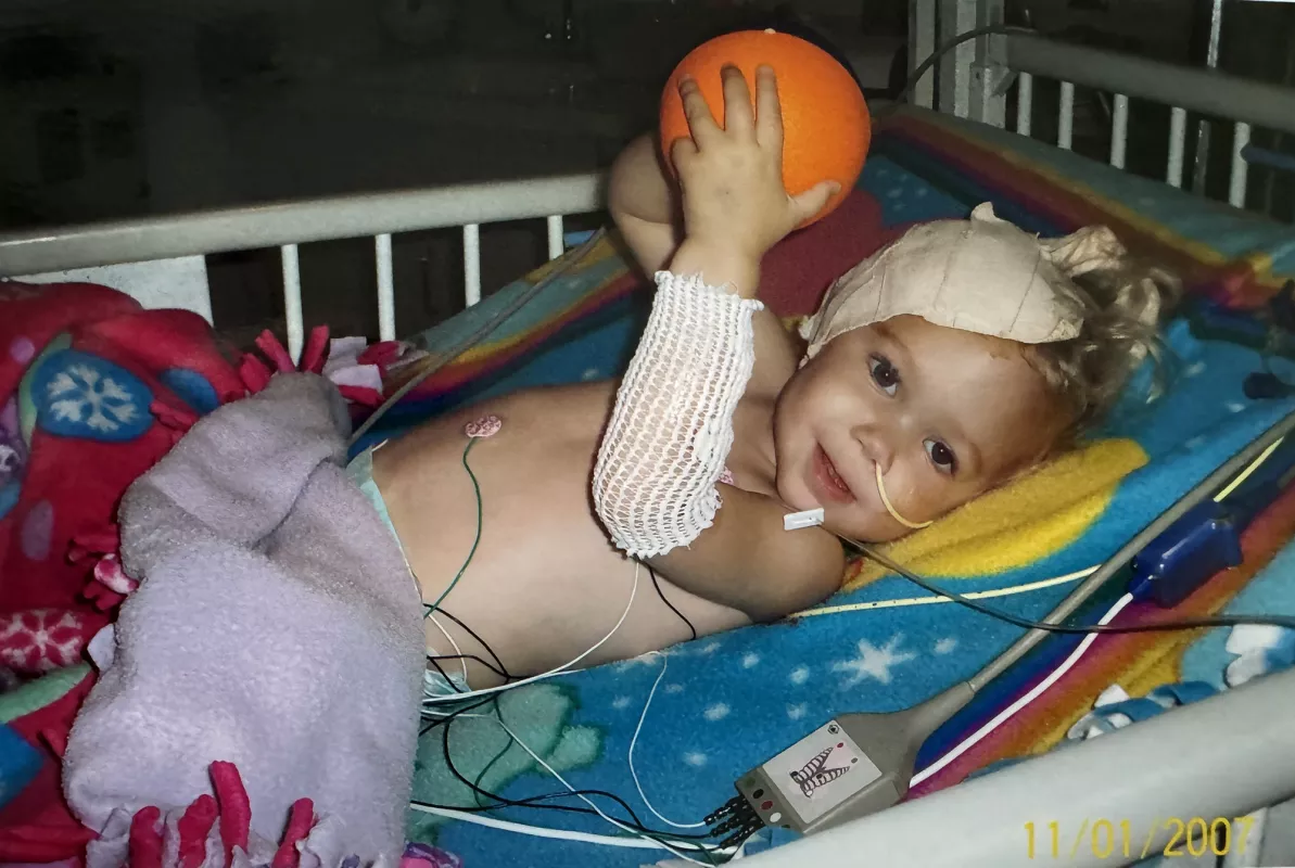 May Gilchrist as an infant playing with a small basketball