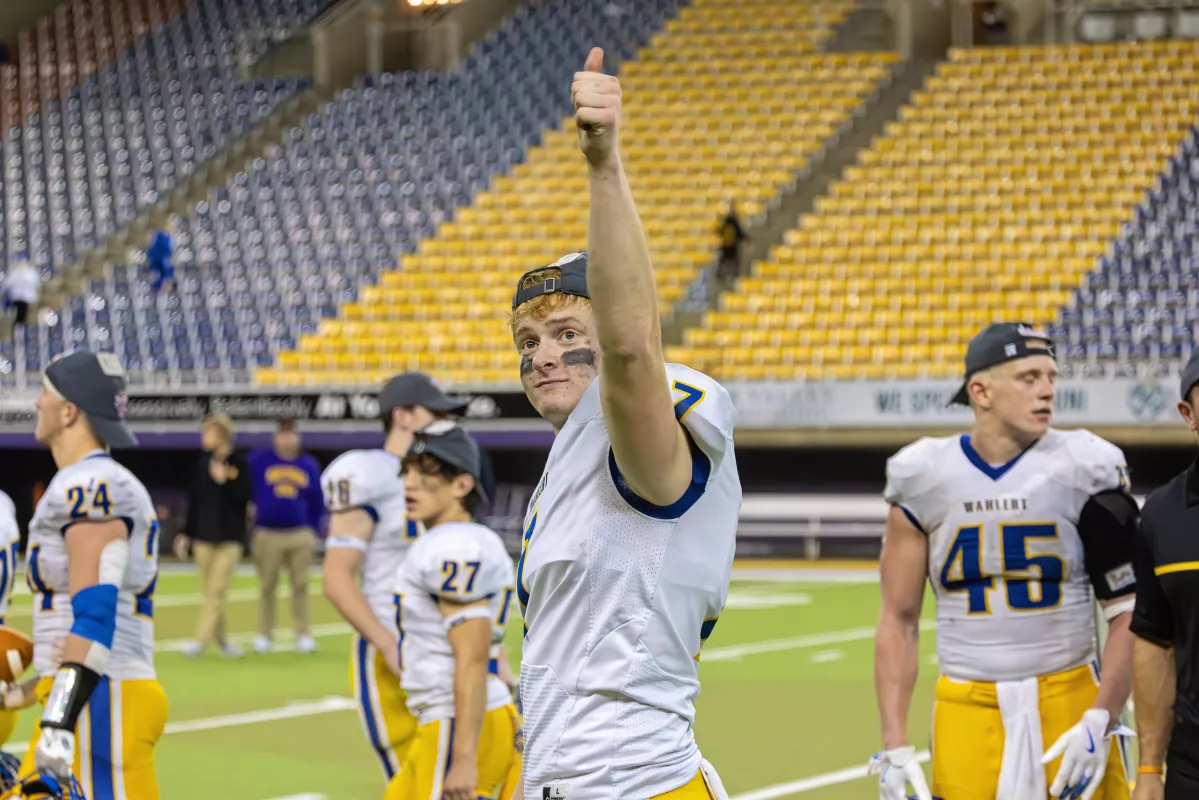 High school senior Nathan Schiesl holding up a triumph thumb during a football game