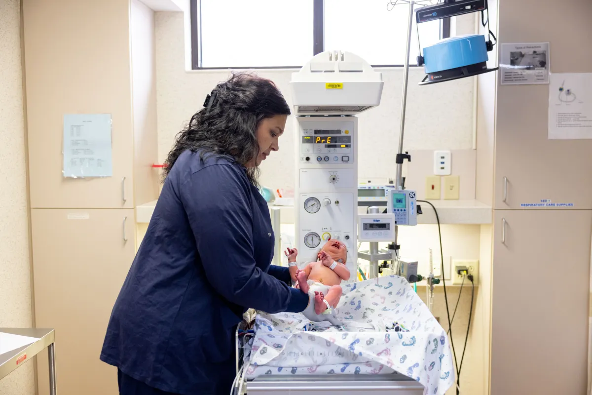 Nurse Katlyn Vantiger with a newborn infant in the newborn nursery at University of Iowa Health Care Medical Center Downtown on Thursday, April 11, 2024. Patient consent on file. Wristbands have been blurred.