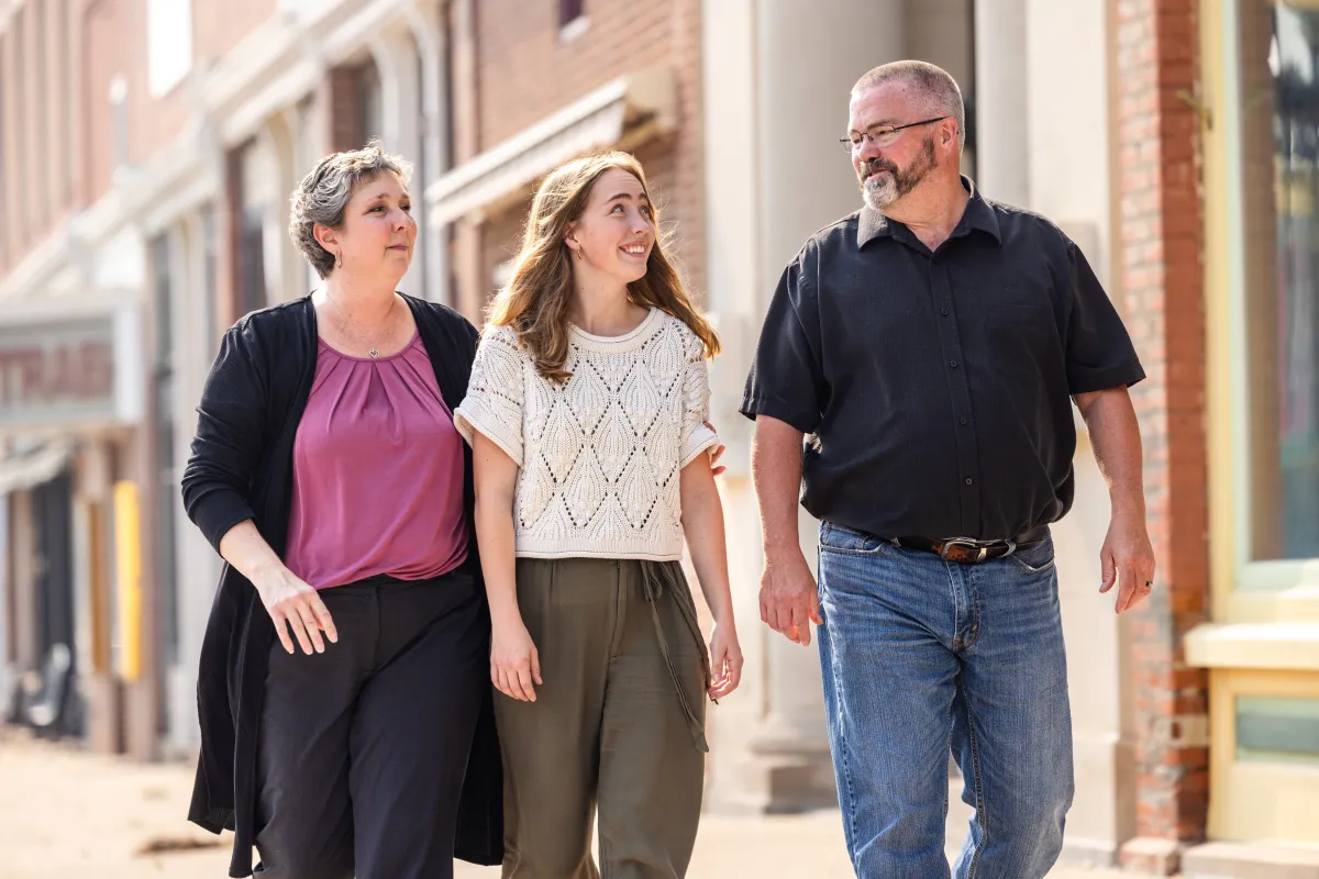 Grace Lidgett in downtown Traer with her parents Tony and Amy on Thursday, July 31, 2025. Grace was diagnosed with cystic fibrosis as an infant, and through therapies that included Ofkambi and now Trikafta, has been able to live an active life that included running on her high school track and cross country teams.