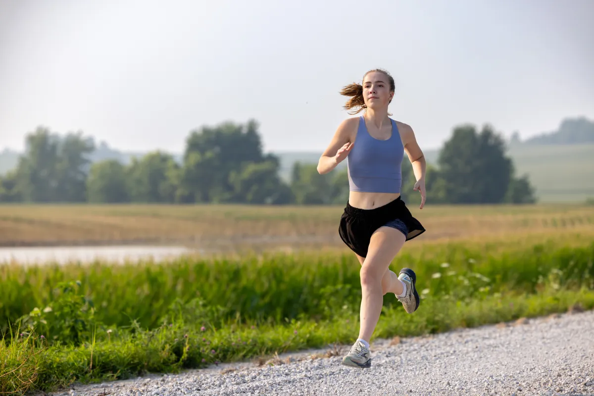 Grace Lidgett runs through rural Tama County on Thursday, July 31, 2025. Grace was diagnosed with cystic fibrosis as an infant, and through therapies that included Ofkambi and now Trikafta, has been able to live an active life that included running on her high school track and cross country teams.
