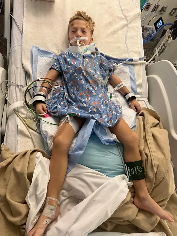 Kid Captain Luke Johnston lying in a hospital bed